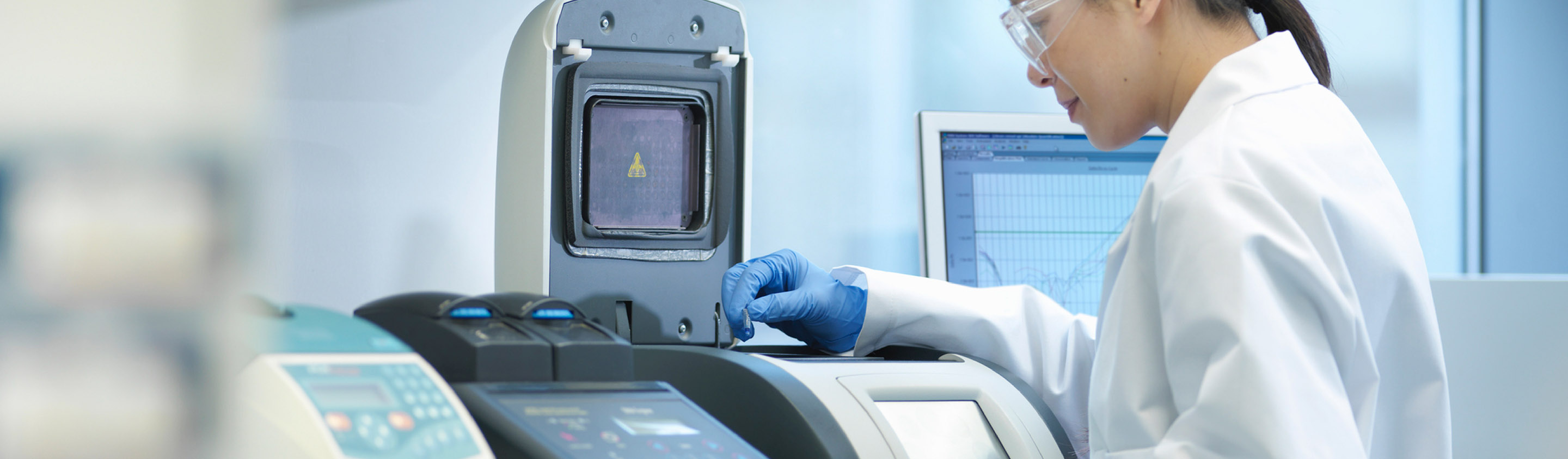 Scientist in lab coat operating an LC-MS instrument for pharmacokinetic analysis