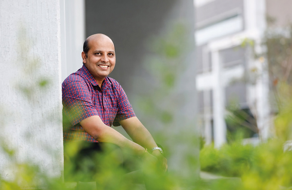 Portrait of Pavan Kumar Kamarajugadda, Aragen employee, seated outdoors on the Aragen campus
