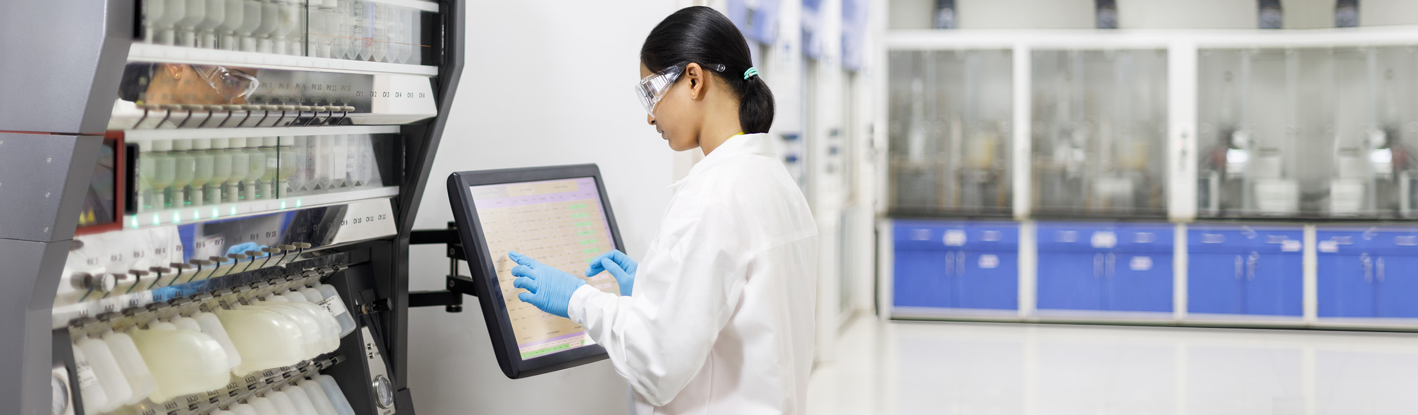 Aragen scientist operating a touchscreen on an automated peptide synthesizer