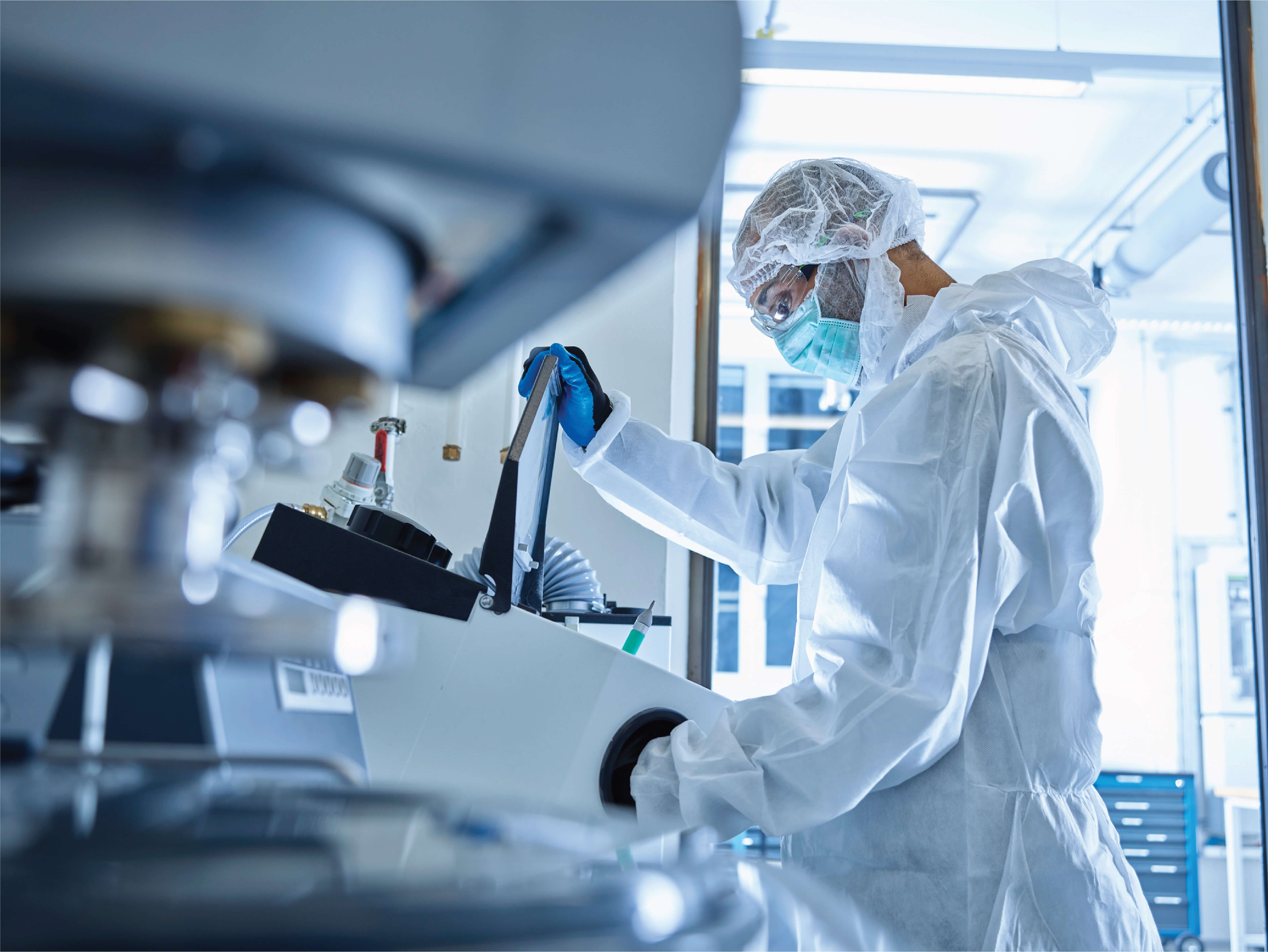 Scientist in cleanroom suit operating an ICP-MS instrument for trace metals analysis