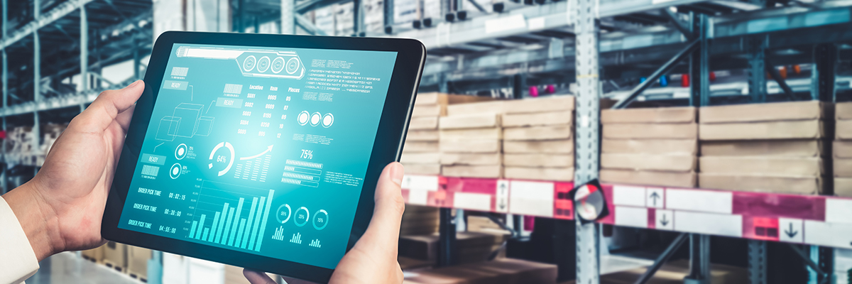 Hands holding a tablet with supply chain dashboards in a warehouse, representing supply partnership