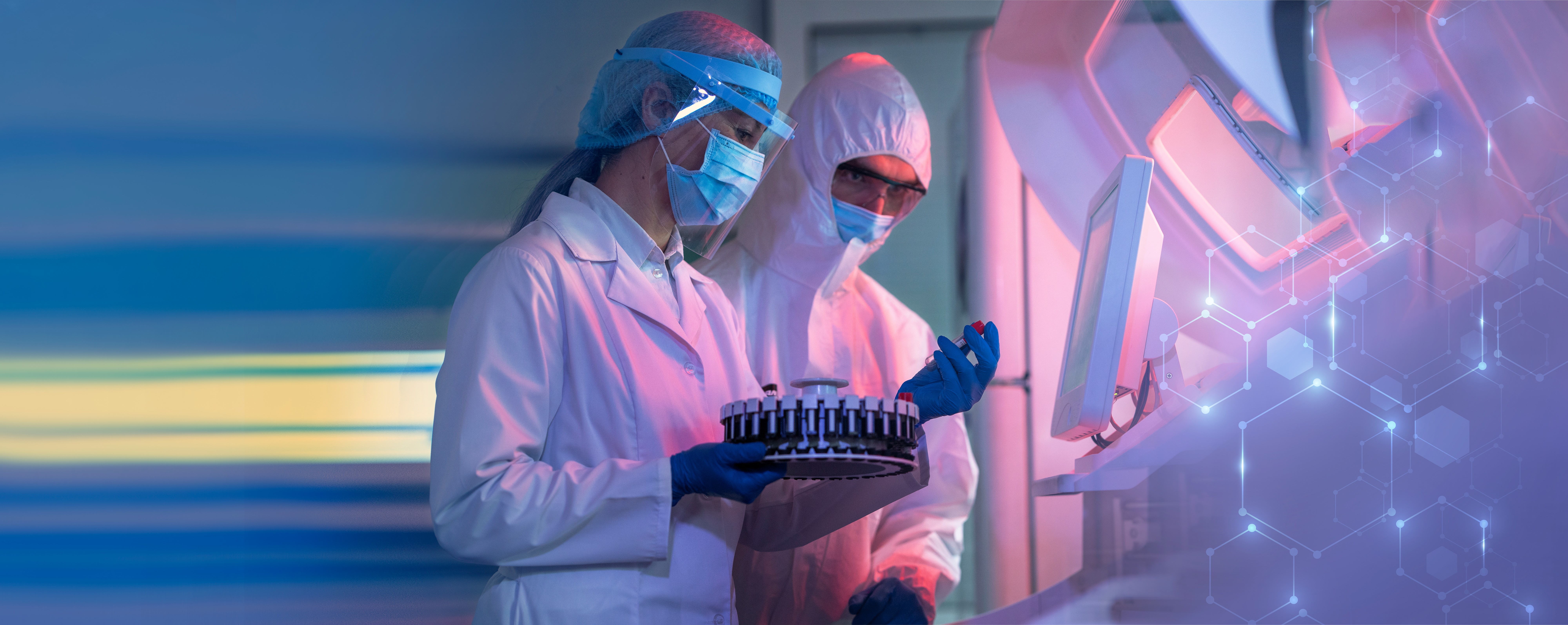 Two Aragen scientists in protective gear reviewing samples with data visualization overlay, representing computational and data science